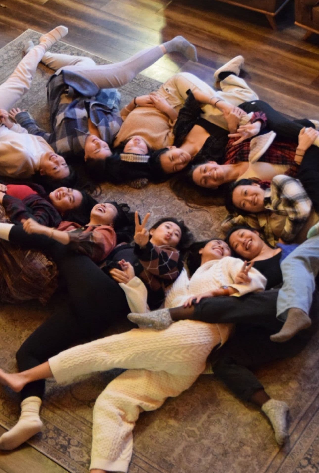 Group lying in a circle, smiling at a retreat